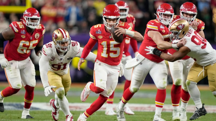 Kansas City Chiefs quarterback Patrick Mahomes (15) scrambles against the San Francisco 49ers in NFL Super Bowl 58 game.