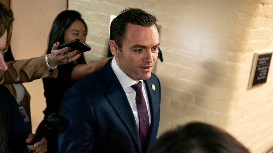 Representative Mike Gallagher is followed by the media as he leaves a meeting.