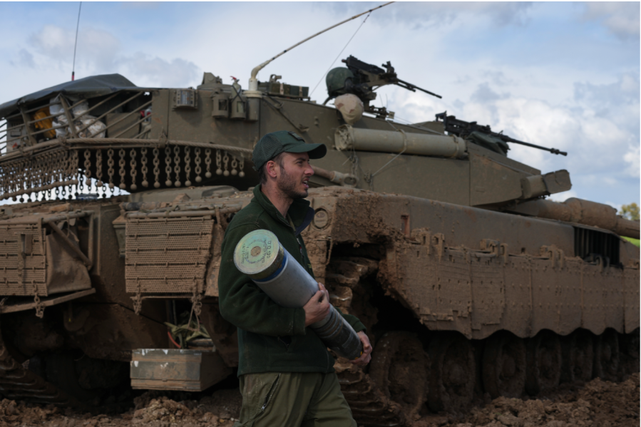 An Israeli soldier carries a tank shell at a staging area in southern Israel, near the Gaza border, Thursday, Feb. 1, 2024.