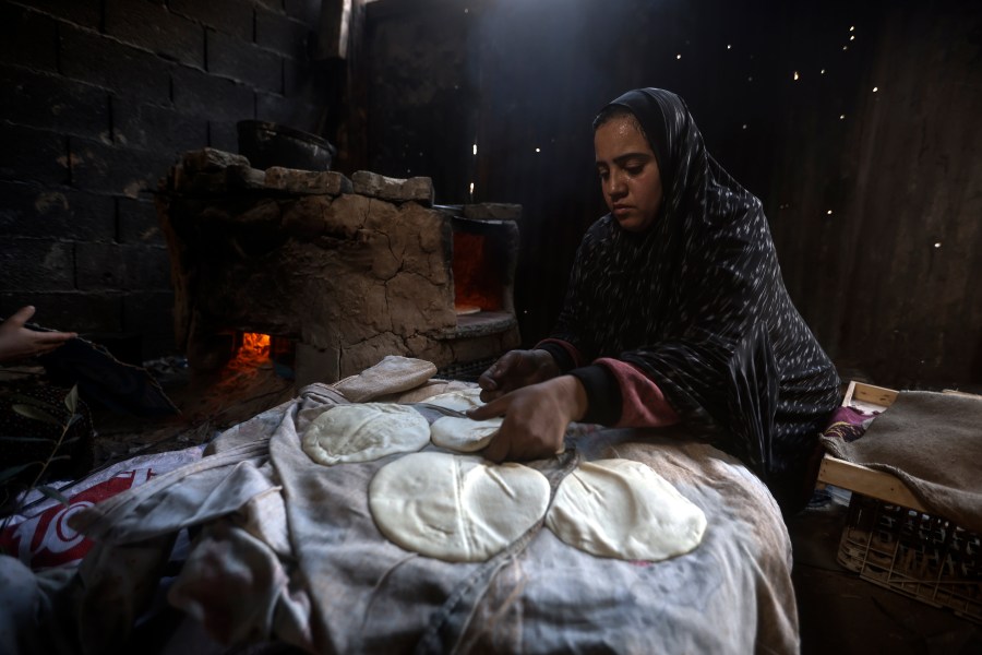 File - A Palestinian woman displaced by the Israeli ground offensive on the Gaza Strip bake bread at a makeshift tent camp in Rafah, Gaza Strip, Monday, Feb. 19, 2024. (AP Photo/Mohammed Dahman, File)