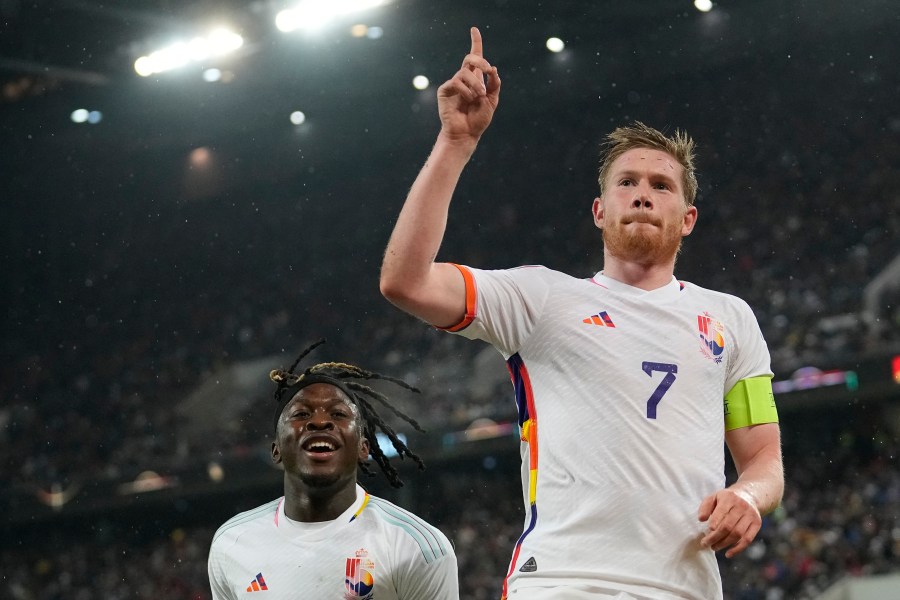 FILE - Belgium's Kevin De Bruyne, right, celebrates after scoring the third goal against Germany during the international friendly soccer match between Germany and Belgium in Cologne, Germany, on March 28, 2023. The Belgium international players taking part in the Euro soccer tournament this summer could well resemble a world-famous reporter. According to leaks on various specialized websites, the Belgium Euro 2024 away kit is a tribute to Tintin. The Belgian federation is set to unveil the new kit on Thursday March 14, 2024 during a press conference at the Hergé Museum. (AP Photo/Martin Meissner, File)