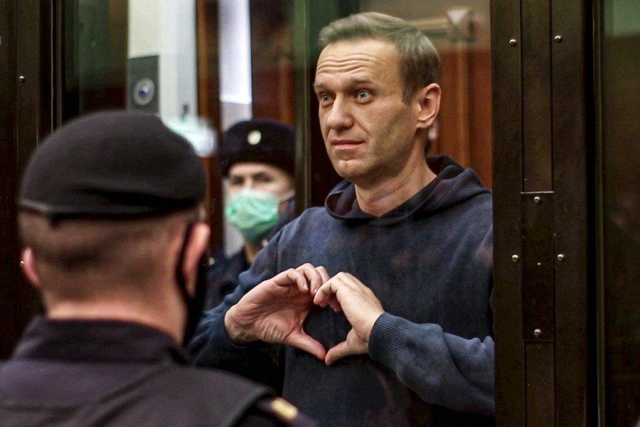 FILE - In this handout photo taken from video provided by the Moscow City Court on Feb. 2, 2021, Russian opposition leader Alexei Navalny shows a heart symbol while standing in a defendants' cage during a hearing in the Moscow City Court in Moscow, Russia. President Vladimir Putin says he supported an idea to release Navalny in a prisoner exchange just days before the man who was his biggest foe died. (Moscow City Court via AP, File)