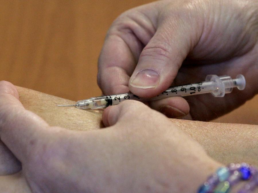 A person administers a vaccine.