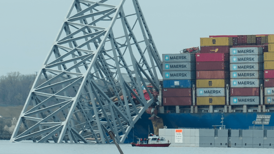 A container ship rests against wreckage of the Francis Scott Key Bridge.