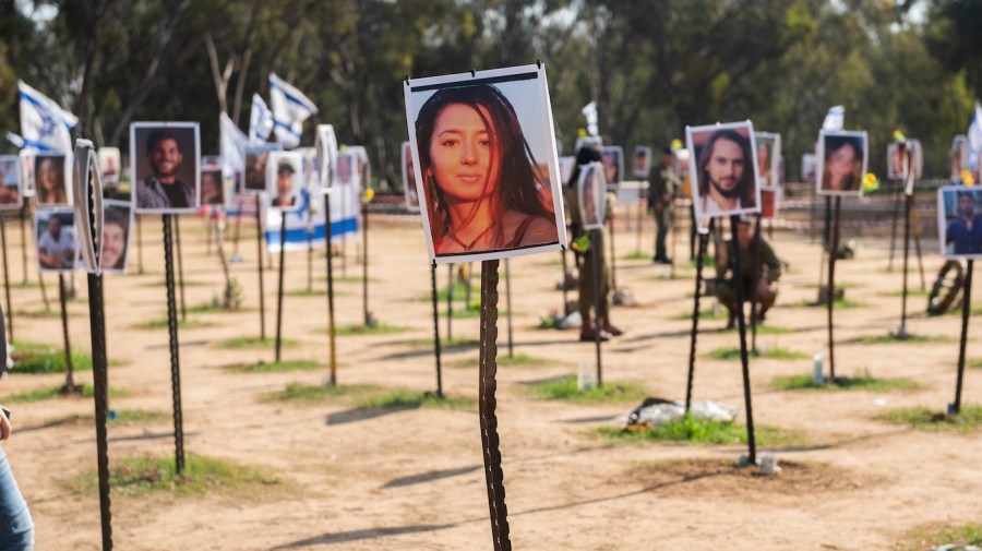 Photos of victims of the October 7, 2023, Hamas attack are displayed in a field on posts as a memorial.