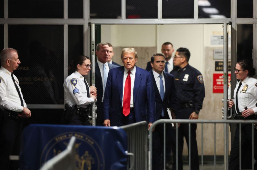 Former president Donald Trump walks out of the courtroom with his lawyer, Todd Blanche.