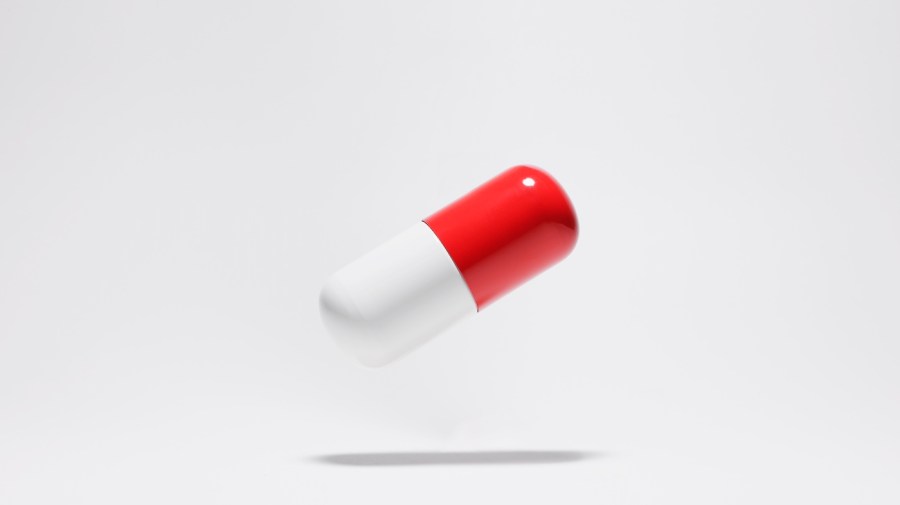 A red and white pill capsule.