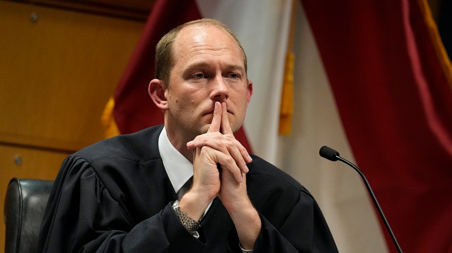 Judge Scott McAfee gestures while presiding in court.