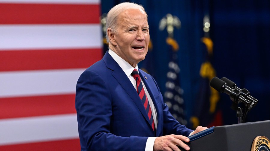 President Joe Biden stands at a podium, delivering a speech.