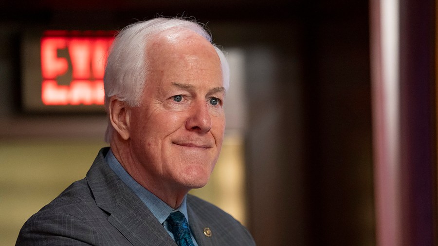 Senator John Cornyn smiles while at a press conference