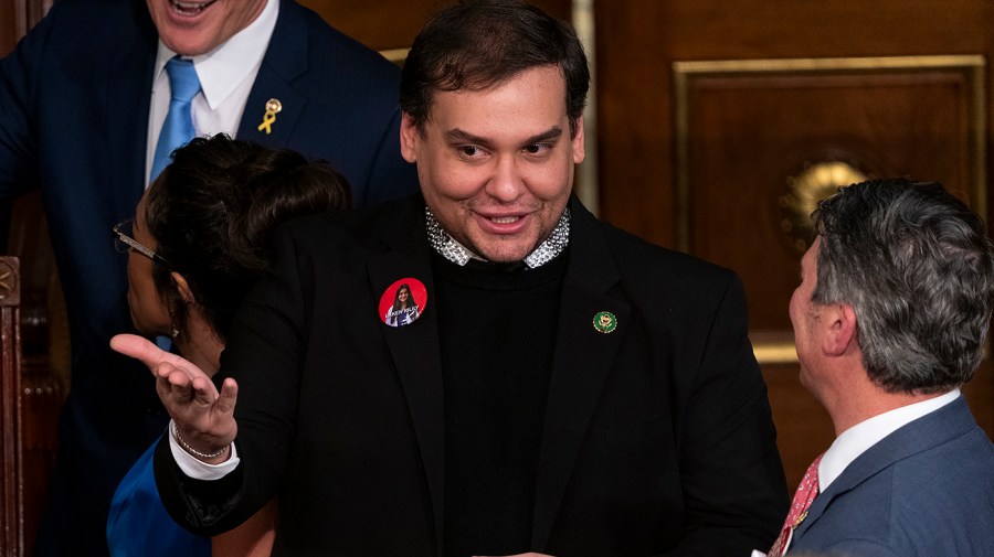 Former Rep. George Santos gestures while speaking to someone ahead of the State of the Union address.