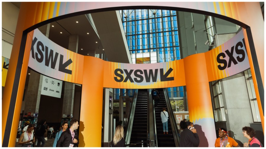 Attendees ride an escalator.