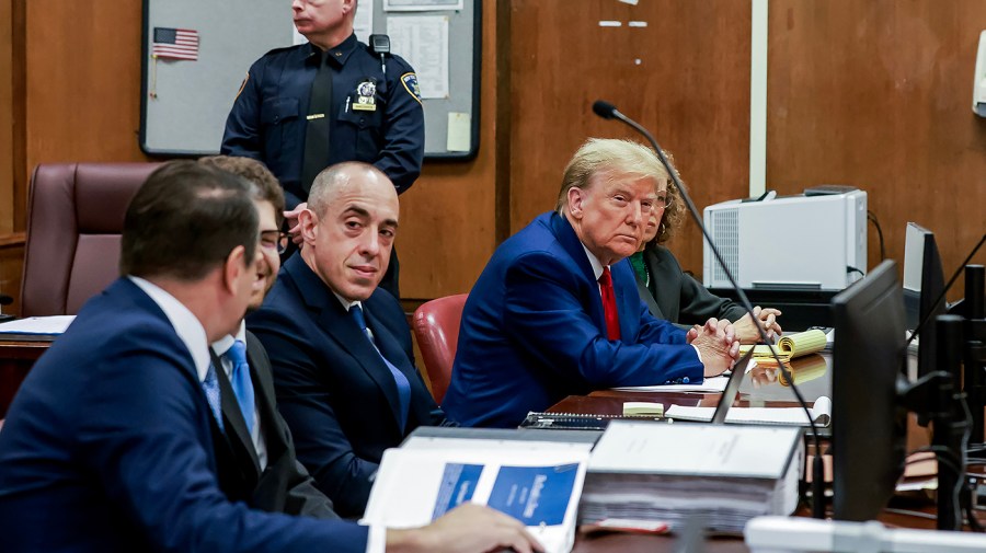 Former President Trump sits with his legal counsel at a pretrial hearing for his hush money case in a New York City courtroom.