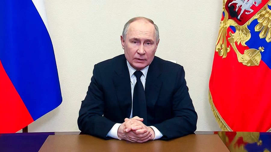 Russian President Vladimir Putin, seated, addressees the nation in Moscow.