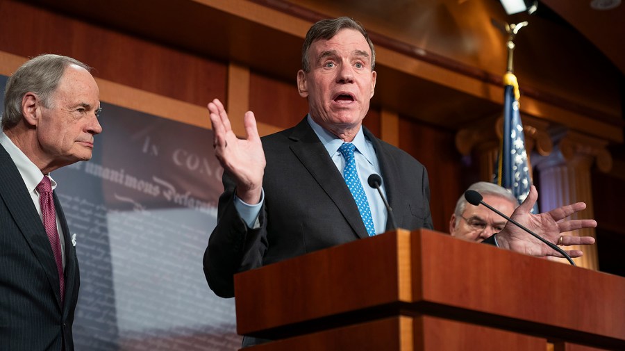 Senator Mark Warner speaks to the press.