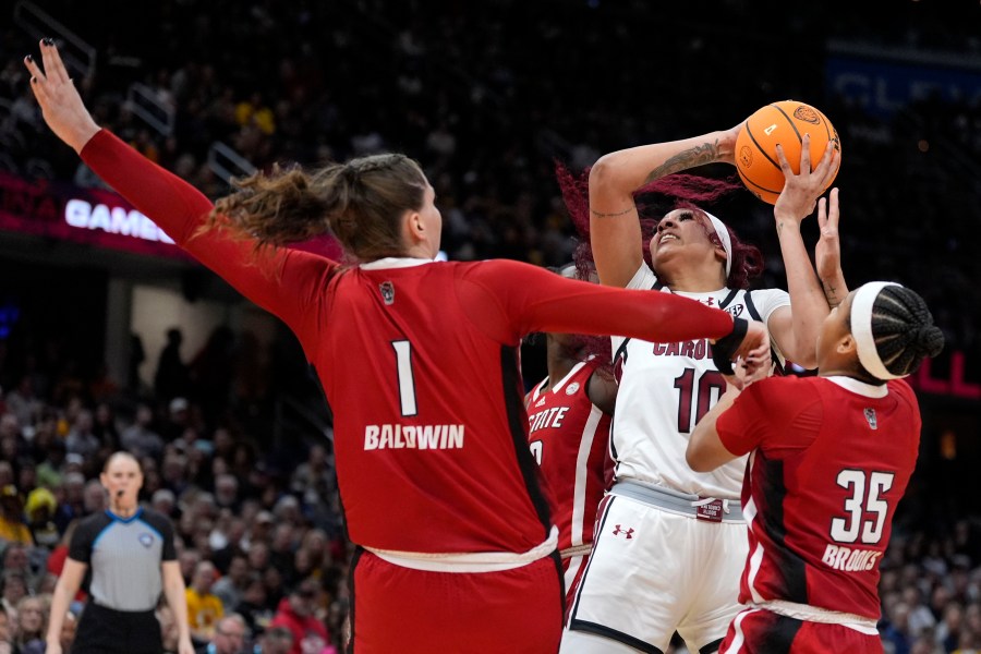 South Carolina center Kamilla Cardoso (10) shoots over North Carolina State center River Baldwin (1) and guard Zoe Brooks (35) during the first half of a Final Four college basketball game in the women's NCAA Tournament, Friday, April 5, 2024, in Cleveland. (AP Photo/Morry Gash)