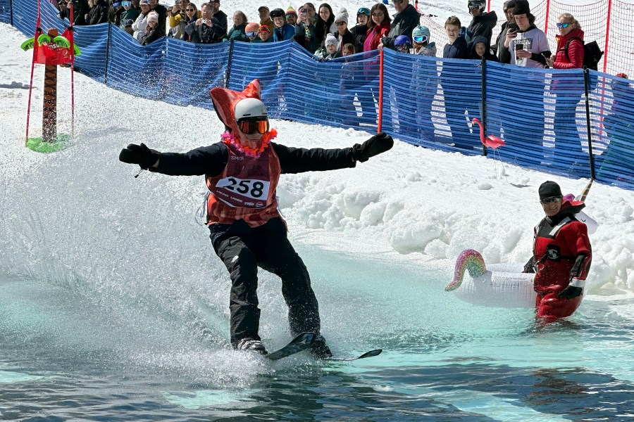 A skier participates in a pond skimming event at Gunstock Mountain Resort, Sunday, April 7, 2024, in Gilford, N.H. The wacky spring tradition is happening this month at ski resorts across the country and is often held to celebrate the last day of the skiing season. (AP Photo/Nick Perry)