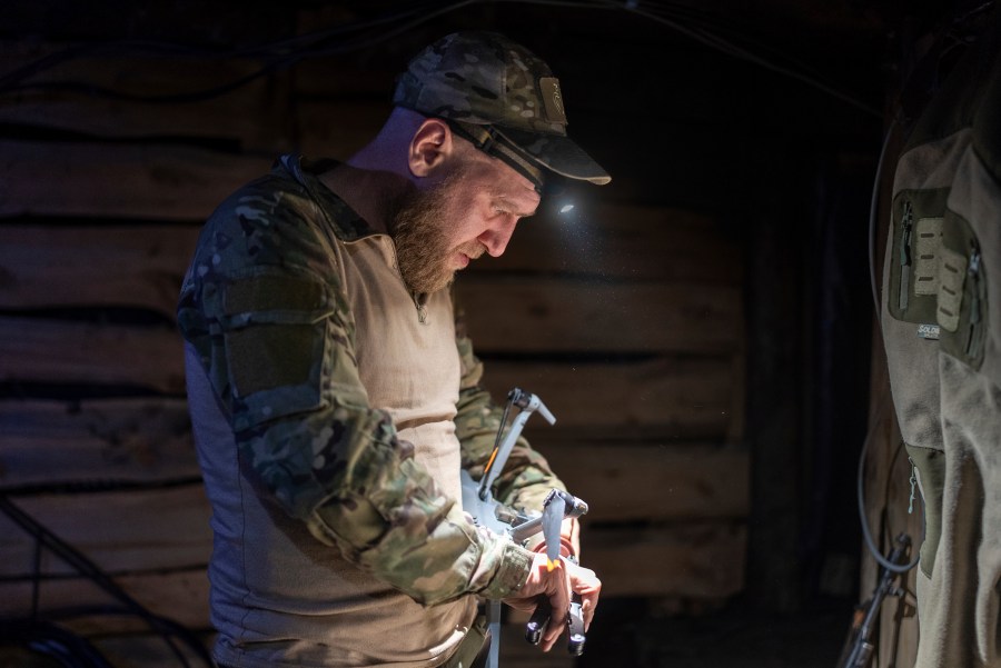 CORRECTS LOCATION TO BAKHMUT IN PHOTO DETAILS - A Ukrainian serviceman from Code 9.2 unit known by call sign Mamay attaches drop bomb to a drone in the trenches at the frontline, few kilometres from Bakhmut, Donetsk region, Ukraine, Tuesday, April 23, 2024. (AP Photo/Alex Babenko)