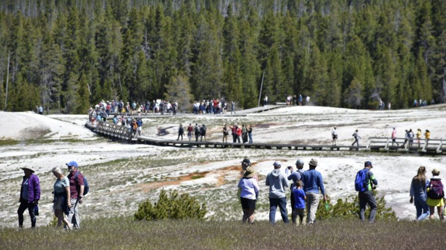 Tourists are see along a boardwalk in Upper Geyser Basin in Yellowstone National Park.