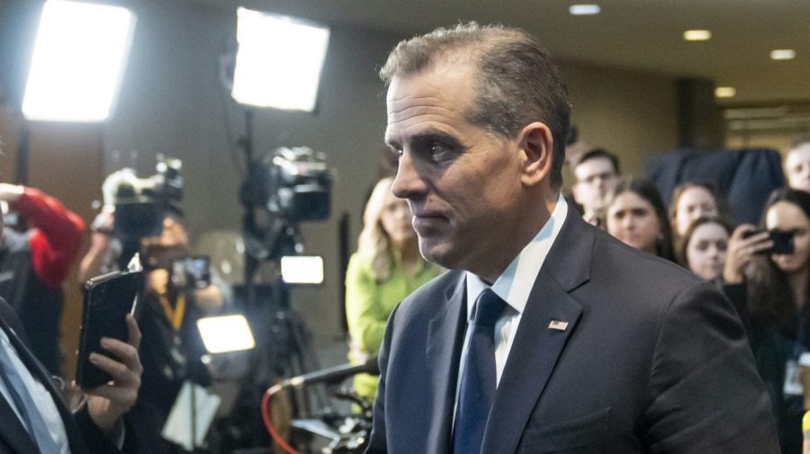 Hunter Biden is seen surrounded by media members and cameras.