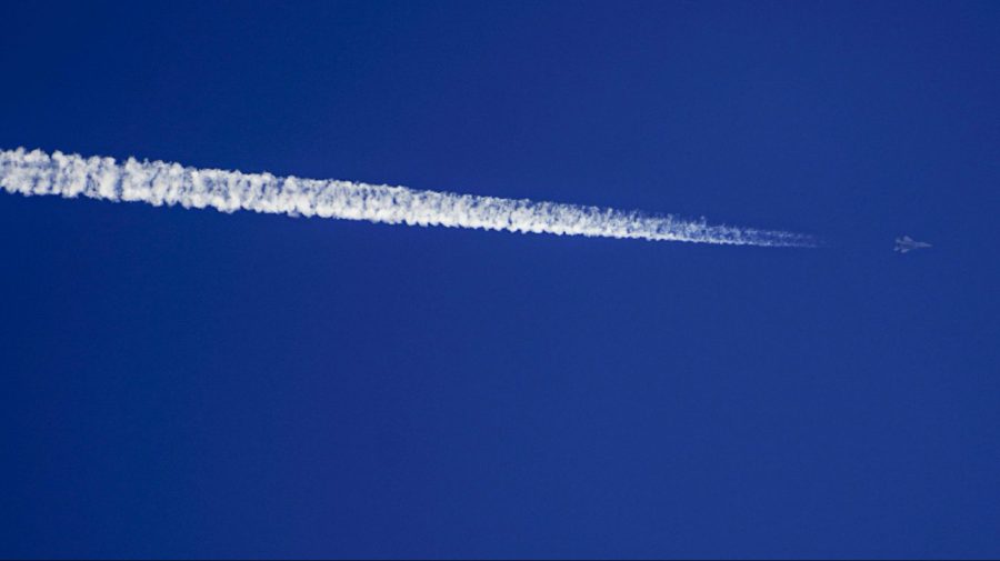 A fighter jet streaks along a deep blue sky.