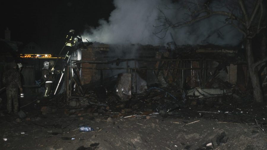 Rescue workers extinguish a house on fire.