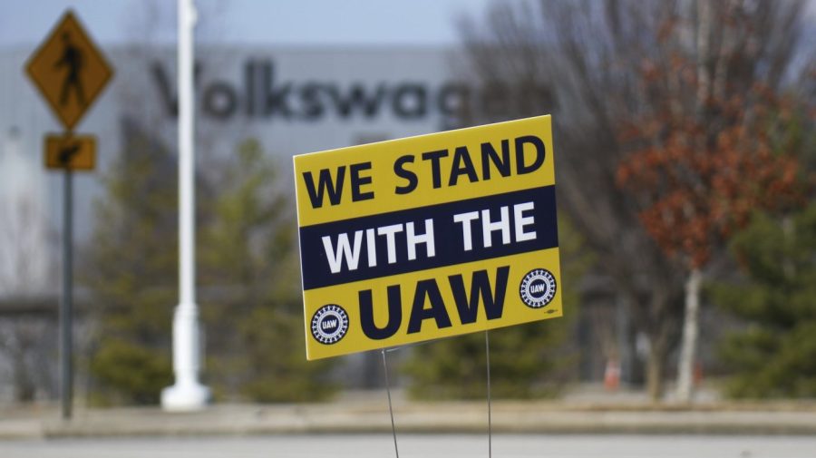 A "We stand with the UAW" sign appears outside of the Volkswagen plant.