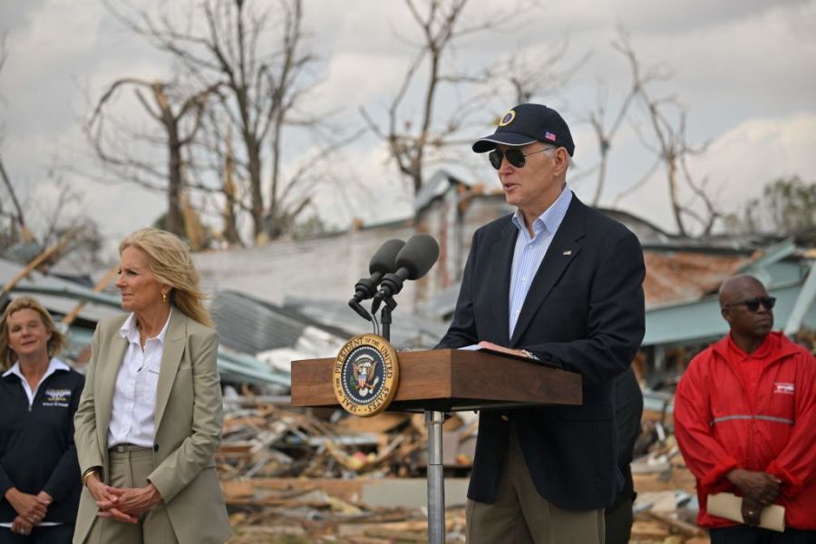 President Biden speaks at the site of a tornado in front of a collapsed structure and debris.