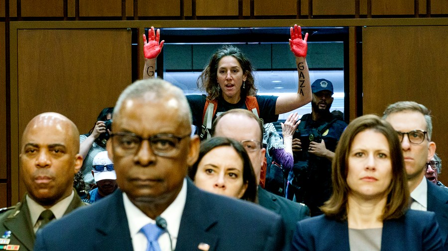 A protester with Code Pink interrupts Secretary of Defense Lloyd Austin’s opening statement during a Senate Armed Services Committee hearing