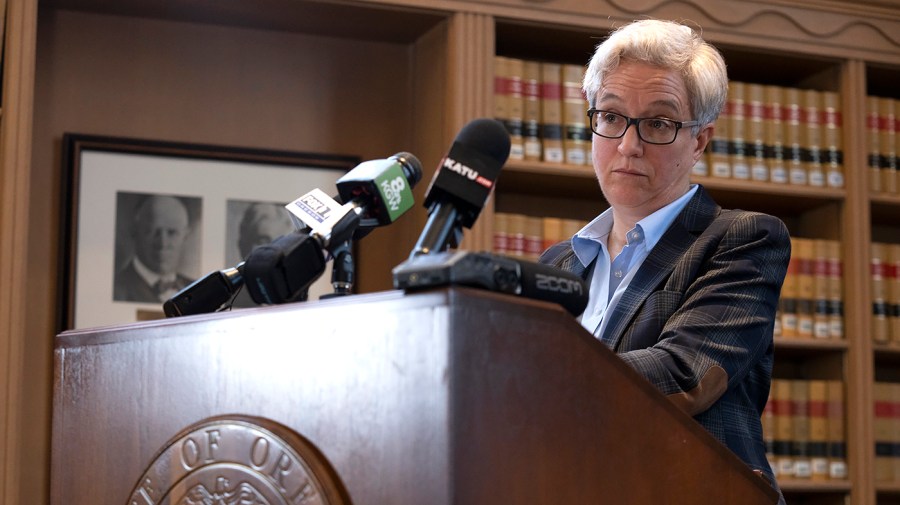 Oregon Governor Tina Kotek listens as a reporter asks a question at a press conference.