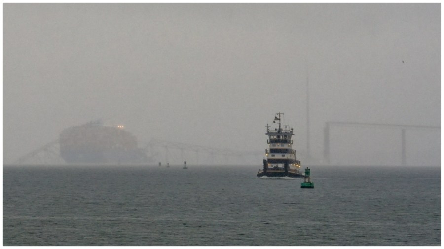 FILE - A tugboat travels along the Patapsco River as the container ship Dali rests on the wreckage of the Francis Scott Key Bridge on Wednesday, March 27, 2024, in Baltimore. (AP Photo/Matt Rourke, File)