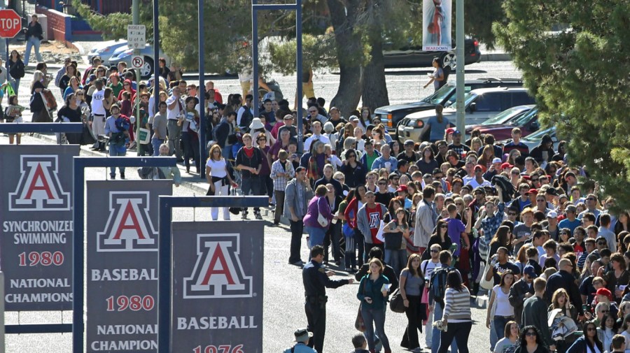 People line up to get into a memorial service at McKale Memorial Center on the University of Arizona campus, Jan. 12, 2011, in Tucson, Ariz.