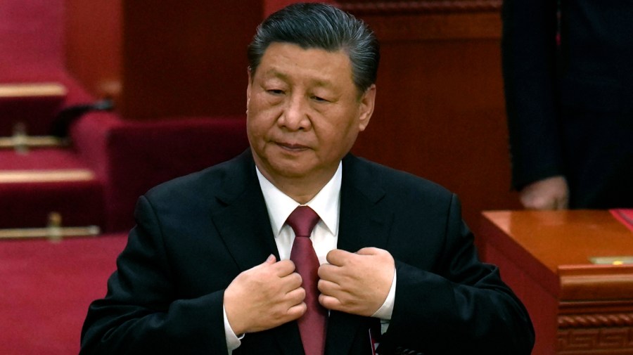 Chinese President Xi Jinping adjusts his jacket during the closing session of the National People's Congress held at the Great Hall of the People in Beijing, Monday, March 11, 2024.