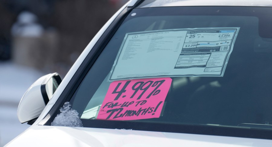 FILE - A sign highlighting the financing interest rate is displayed near the price sticker on an unsold 2023 vehicle at a Mercedes-Benz dealer on Nov. 30, 2023, in Loveland, Colo. The Federal Reserve’s decision Wednesday, May 1, 2024 to keep its benchmark rate at a two-decade high should have ripple effects across the economy. Mortgage rates, credit card rates, and auto loan rates will all likely maintain their highs, with consequences for consumer spending. (AP Photo/David Zalubowski, file)