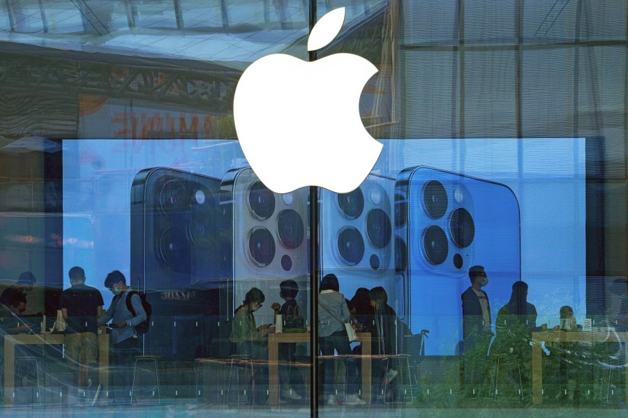 FILE - People try out iPhone products at an Apple Store in Beijing, Sept. 28, 2021. A federal judge on Wednesday questioned whether Apple has set up a gauntlet of exasperating hurdles to discourage the use of alternative payment options in iPhone apps, despite a court order seeking to create more ways for consumers to pay for digital services. (AP Photo/Andy Wong, file)