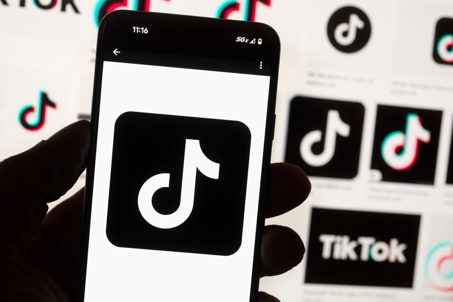 FILE - The TikTok logo is displayed on a mobile phone in front of a computer screen, Oct. 14, 2022, in Boston. TikTok will begin labeling content created using artificial intelligence when it's uploaded from certain platforms. TikTok says its efforts are an attempt to combat misinformation from being spread on its social media platform. The announcement came on ABC's “Good Morning America” on Thursday, May 9, 2024. (AP Photo/Michael Dwyer, File)