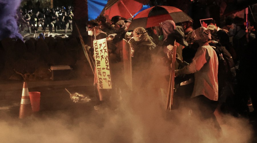 Demonstrators retreat as several area law enforcement agencies clear an encampment of pro-Palestinian protesters off the University of Arizona campus, early Friday, May 10, 2024, Tucson, Ariz. (Kelly Presnell/Arizona Daily Star via AP)