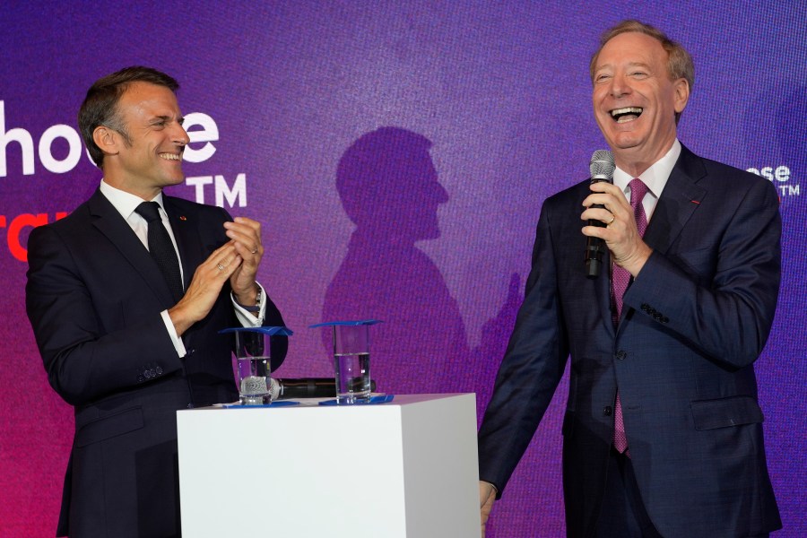 French President Emmanuel Macron, left, applauds Microsoft CEO Brad Smith at the French Microsoft headquarters in Issy-les-Moulineaux, outside Paris, Monday, May 13, 2024. Microsoft, which has been present in France for 41 years, is announcing a 4 billion euro investment this year, the largest to date in the country, to support French growth in the new artificial intelligence economy. (AP Photo/Thibault Camus, Pool)