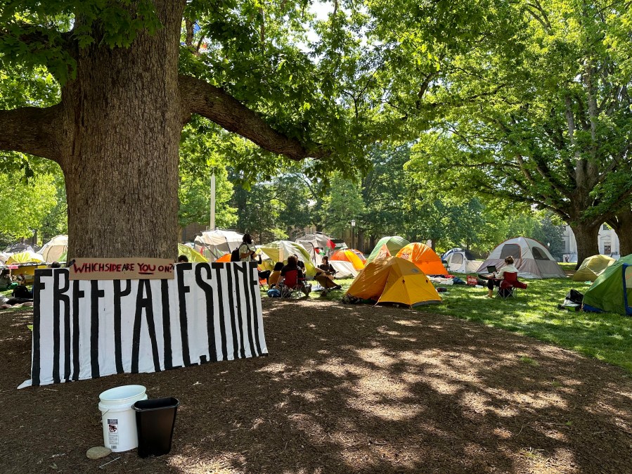 FILE - Students and other community members sit outside tents in University of North Carolina at Chapel Hill's central grounds, Polk Place, as part of an encampment protest, April 29, 2024. On Monday, May 13, the University of North Carolina at Chapel Hill Board of Trustees approved a change that would divert $2.3 million of diversity funding to go toward public safety and policing. The vote to shift more funding to public safety comes as continued pro-Palestinian protests on UNC's campus have resulted in several arrests in recent weeks. (AP Photo/Makiya Seminera, File)