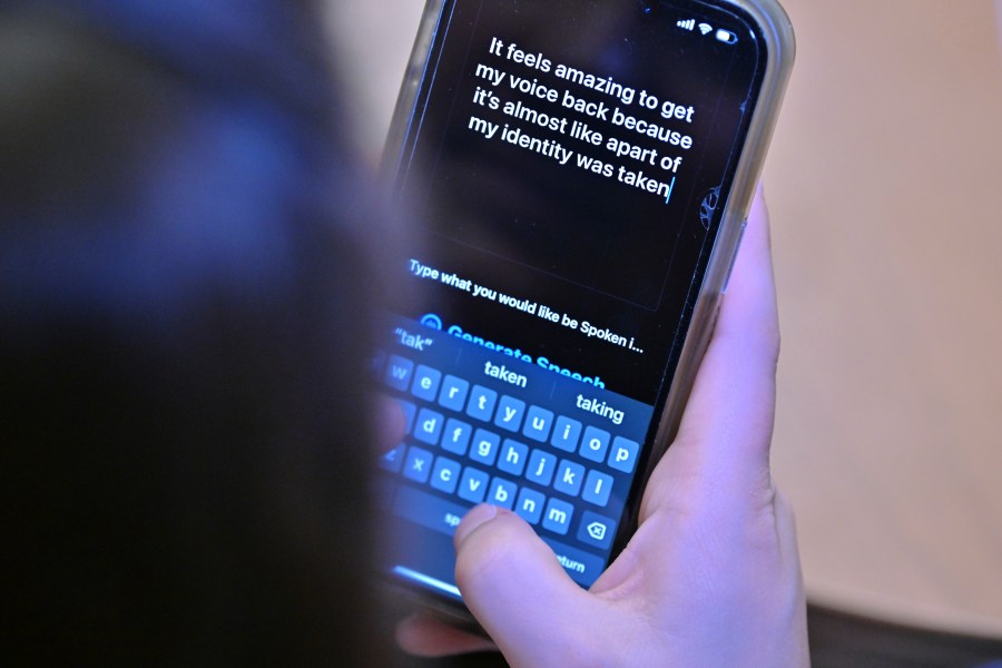 Alexis Bogan types a response to a reporter's question with an app which approximates her lost voice, Thursday, March 11, 2024, at Rhode Island Hospital in Providence, R.I. Doctors treating Bogan, whose speech was impaired by a brain tumor, used a voice-cloning tool from OpenAI to recreate her previous voice. (AP Photo/Josh Reynolds)