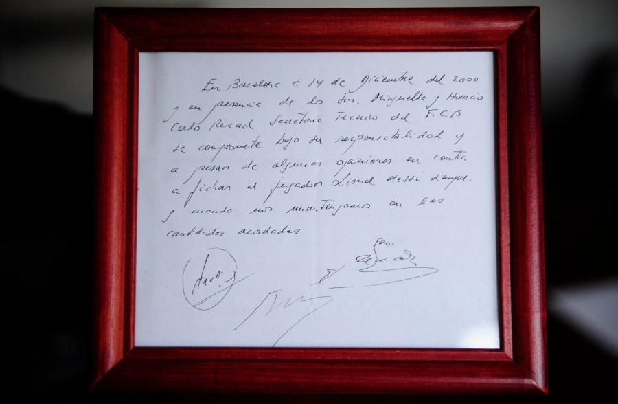 FILE - A framed copy of the napkin linking the 13-year-old Lionel Messi to FC Barcelona is seen in Barcelona, Spain on Jan. 5, 2012. British auction house Bonhams says the famous napkin that linked a young Lionel Messi to Barcelona has sold for $965,000. An agreement in principle to sign then 13-year-old Messi was written on the napkin almost 25 years ago at a Barcelona tennis club. (AP Photo/Manu Fernandez, File)