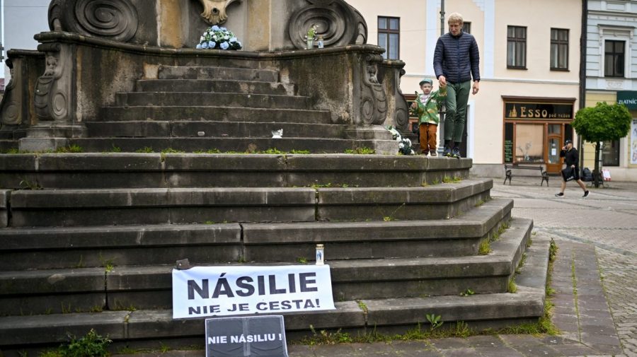 A man walks with a child next to a banner that reads "Violence is Not the Way" and " No Violence" in Banska Bystrica, central Slovakia, Friday, May 17, 2024. When a gunman shot Slovak Prime Minister Robert Fico this week, shock rippled across the Central European country — even though the pro-Russia leader himself warned that the country was so divided that an assassination attempt was possible. (AP Photo/Denes Erdos)