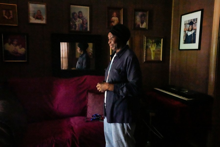 Carrie Jenkins stands in her living room by the light of her open front door, the only light in her home since losing power the night before in the aftermath of a severe storm, Friday, May 17, 2024 in Houston. (Brett Coomer/Houston Chronicle via AP)