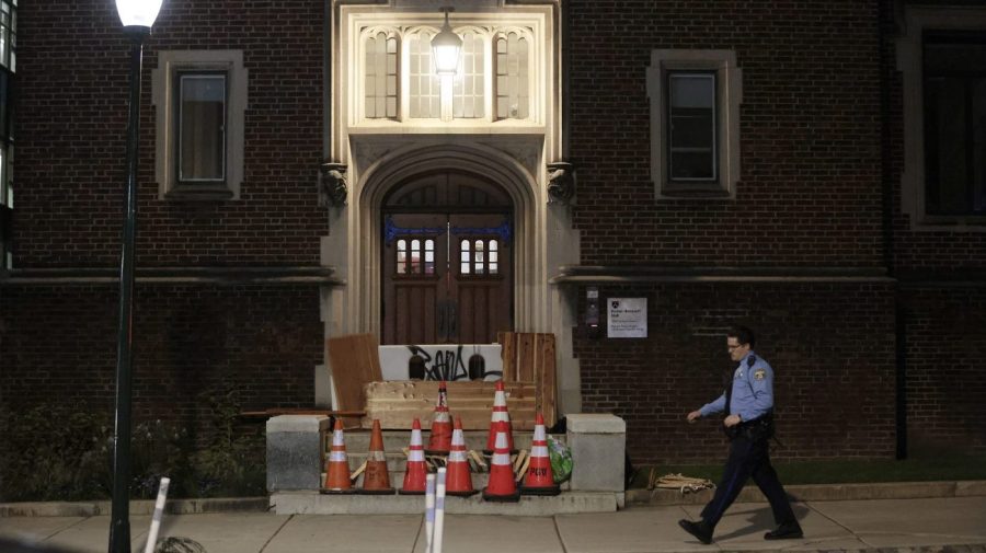 Police walk by a side entrance to Fisher-Bennett Hall where pro-Palestine supporters had erected barricades before clashing with police on the University of Pennsylvania campus near 34th and Walnut St. in Philadelphia on Friday, May 17, 2024. Authorities say a half-dozen University of Pennsylvania students were among 19 pro-Palestinian protesters arrested during an attempt to occupy a building on campus. University police say seven remained in custody Saturday awaiting felony charges from Friday's incident, including one person who allegedly assaulted an officer. (Elizabeth Robertson/The Philadelphia Inquirer via AP)