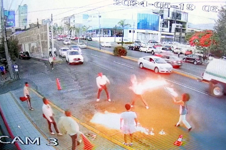 In this image taken from video provided by Jorge Toscano, a flame-swallower, right, and a group of guitar-toting mariachis fight, Sunday, May 19, 2024 in Morelia, Mexico. (Jorge Toscano via AP)