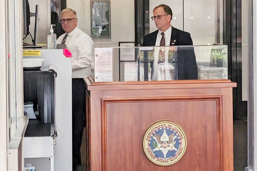 Apple executive Phil Schiller, left, goes through courthouse security in Oakland, Calif., on May 22, 2024 before testifying in an ongoing legal battle over the fees the iPhone maker is charging for digital transactions completed in apps using independent payment systems. (AP Photo/Mike Liedtke)