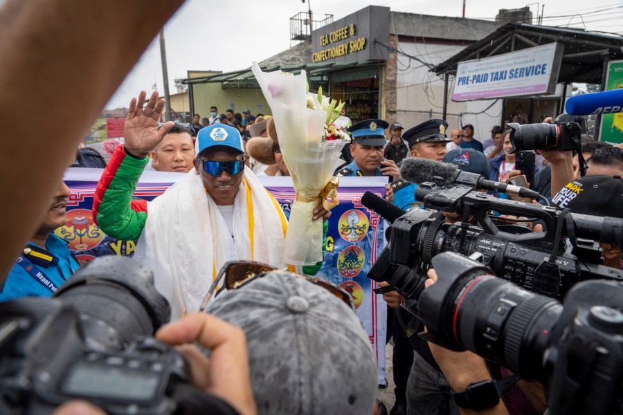 Renowned Sherpa mountain guide Kami Rita returning from Mount Everest after his record 30th successful ascent, waves to media after he arrives at the airport in Kathmandu, Nepal, Friday, May 24, 2024. (AP Photo/Niranjan Shrestha)