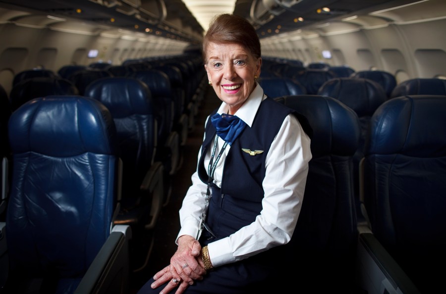 FILE - Flight attendant Bette Nash poses on a plane at Logan International Airport in Boston on Dec. 18, 2014. Nash, who was once named the world's longest-serving flight attendant, has died. She was 88. American Airlines, Nash's employer, announced her passing on social media Saturday. (AP Photo Dina Rudick/Boston Globe via AP, File)