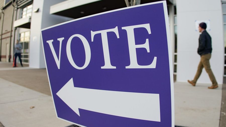 A vote sign with an arrow points people to a polling location.