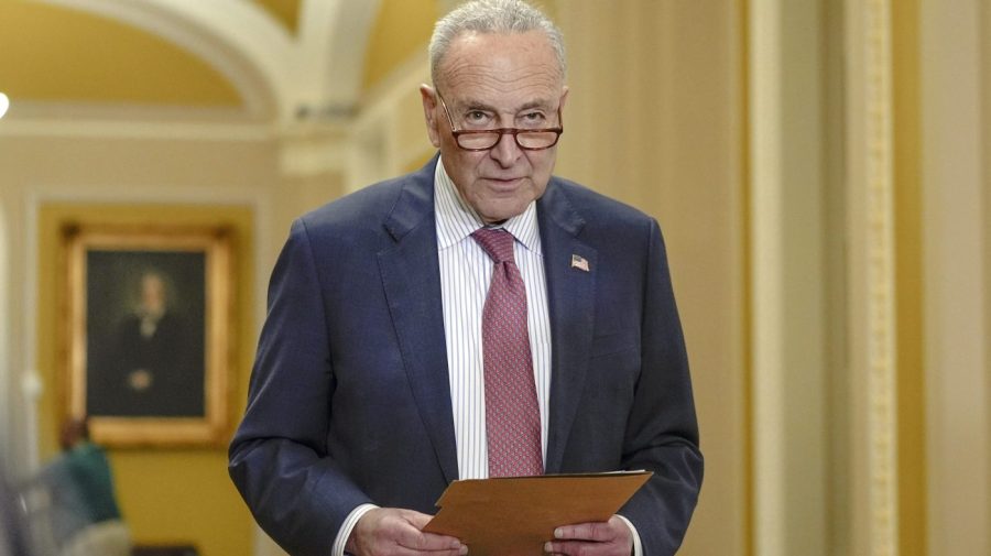 Chuck Schumer carries documents while seen at the Capitol.